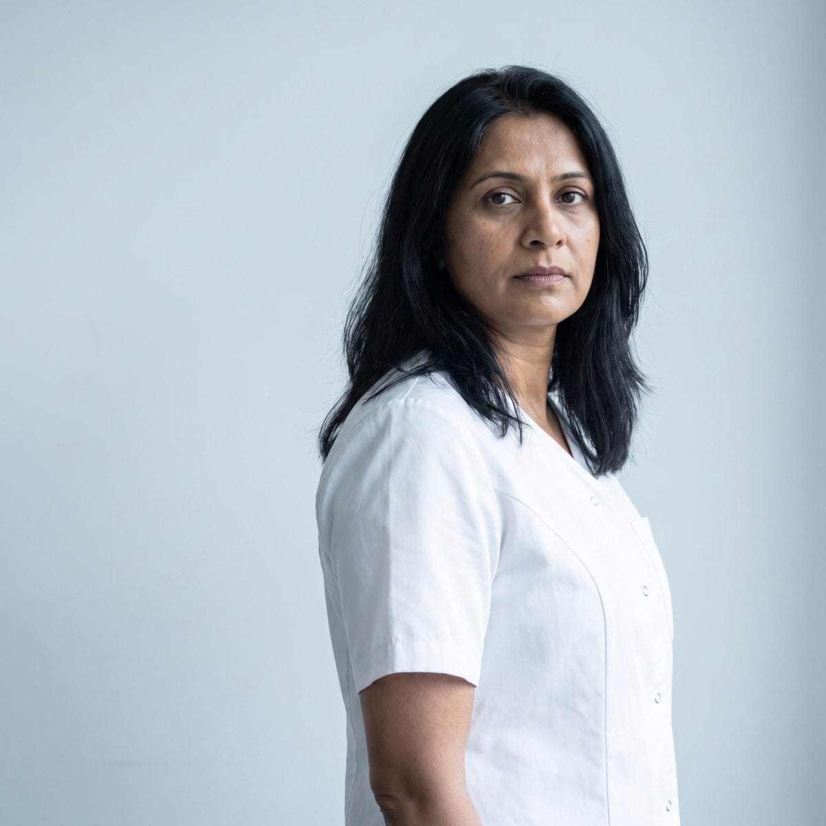 Portrait of the practice's medical director against a plain pale background.